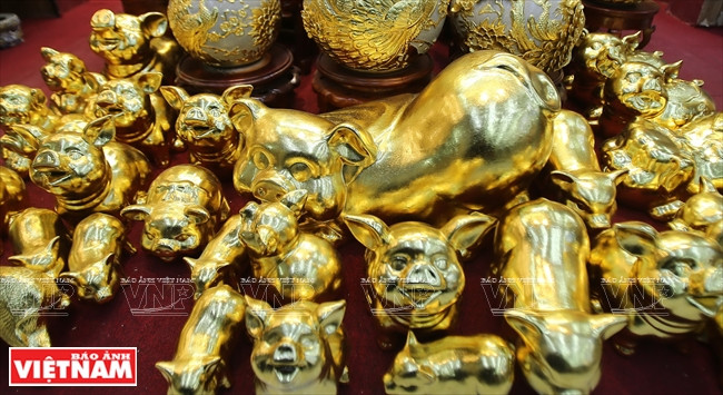 Cerdos cerámicos cubiertos con láminas de pan de oro. (Fuente: VNA)