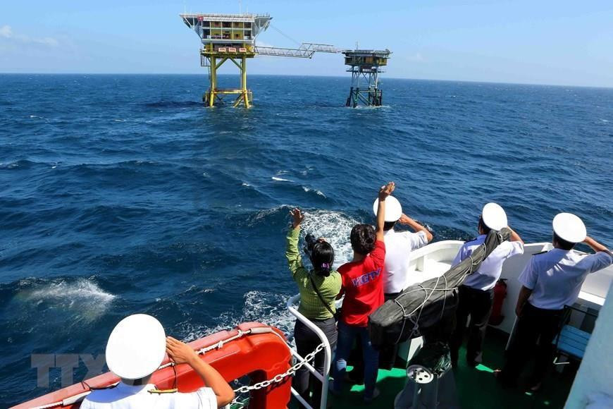 Los soldados y periodistas de la Región Naval 2 a bordo de la embarcación Truong Sa 19 saludan a los militares en la plataforma DK1. (Foto: VNA)