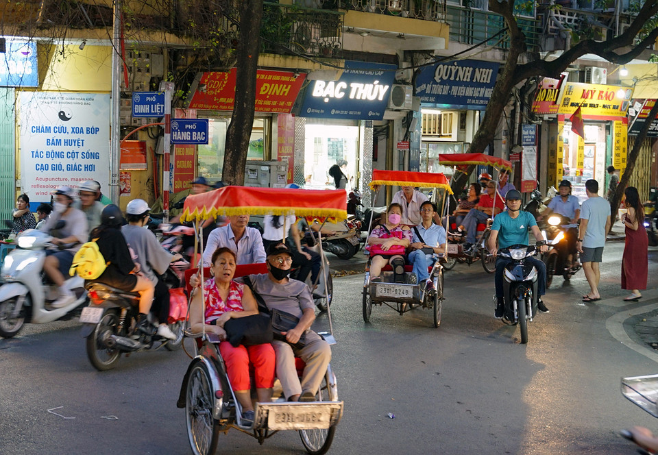 Turistas extranjeros visitan la calle de Dinh Liet en triciclos (Fuente:VNA)