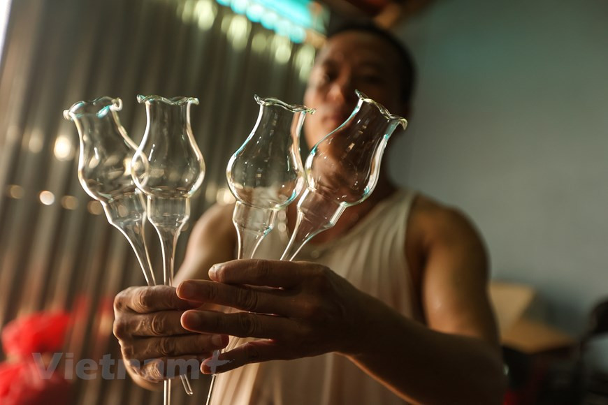 Aunque también puede ser producido por el ser humano, el vidrio es un material inorgánico duro, frágil, transparente y amorfo que se encuentra en la naturaleza. El vidrio artificial se usa para hacer ventanas, lentes, botellas y una gran variedad de productos. Dicho material constituye un tipo de cerámica amorfa. El vidrio se obtiene a unos 1.500 °C a partir de arena de sílice, carbonato de sodio y caliza. A partir de 1960, el soplado de vidrio ha sido la principal ocupación de la mayoría de los residentes de la comuna de Thong Nhat. La aldea de Giap Long deviene la zona más desarrollada en este oficio en la comuna, donde se concentran muchos trabajadores hábiles. (Fuente:Vietnam+) 