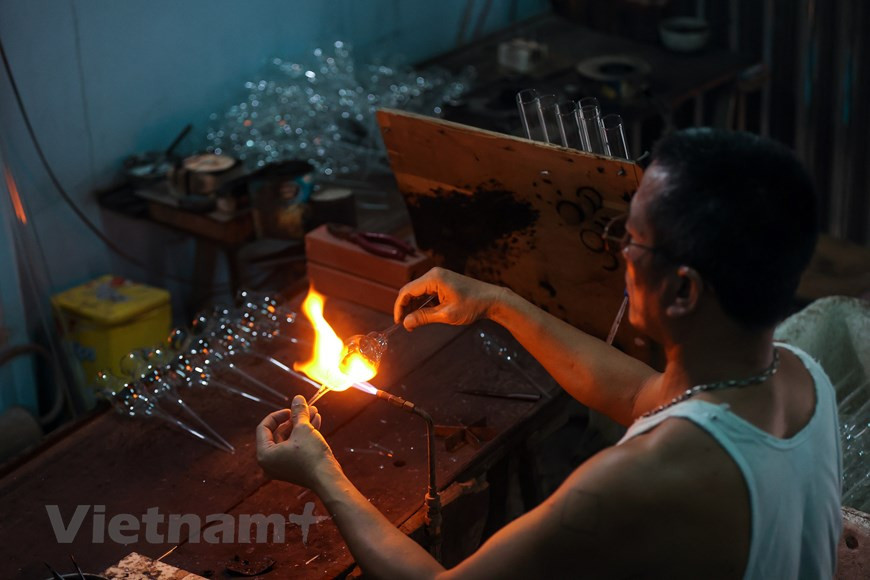 Desde 1960, el soplado de vidrio ha sido la principal ocupación de la mayoría de los residentes de la comuna de Thong Nhat. La aldea de Giap Long resalta como la zona más desarrollada en este oficio en la comuna, donde se concentran muchos trabajadores hábiles, quienes pueden elaborar productos complicados y delicados de vidrio. Le Xuan Tien, con más de dos décadas de experiencia en esta labor, contó que hace diez años, casi toda la comuna se dedicaba a este trabajo. Los aldeanos podían hacer cualquier producto doméstico común, como botellas, vasos, o tapones de termos. Comentó que para confeccionar artículos de calidad, los sopladores de vidrio deben conocer muy bien las características de este material. (Fuente:Vietnam+) 