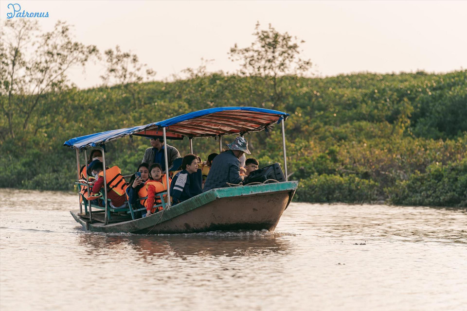 Turistas comparten un paseo en bote por el bosque de manglares. (Foto: VNA)