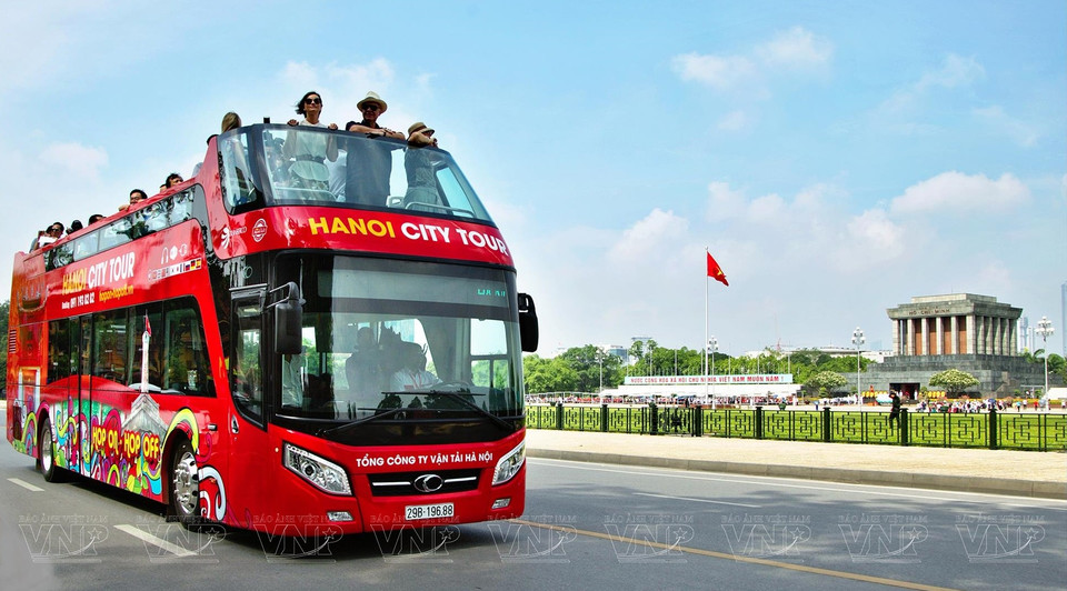Turistas extranjeros en un autobús de dos pisos disfrutan del paisaje del Mausoleo dedicado al Presidente Ho Chi Minh y la plaza Ba Dinh (Fuente: VNA)
