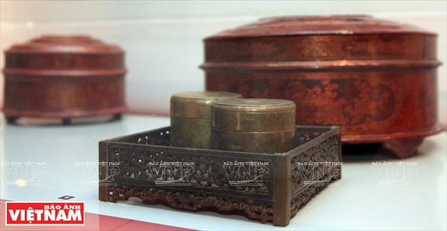 En la foto, una chiquita de bronce para el betel y nueces de areca, utilizada en la boda tradicional de los Kinh, la mayor nacionalidad en Vietnam. Los objetos son ordenados en tres segmentos: La mujer en la familia, la mujer en la historia, y moda femenina. 