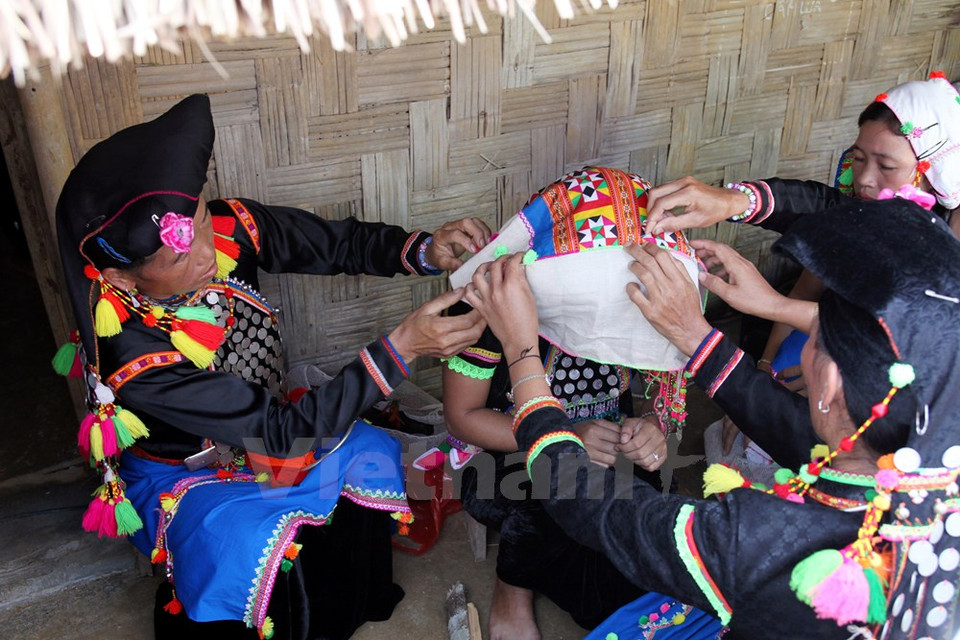 Las mujeres en la familia ponen el velo a la novia. (Fuente: VNA)