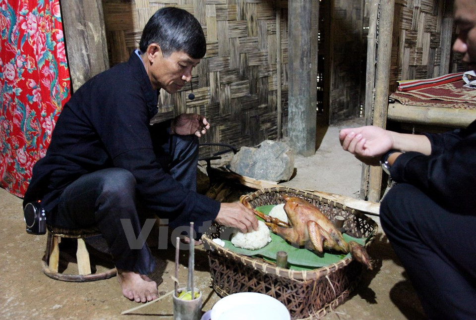 El líder de la línea prepara la oferta dedicada a los antepasados. Está sentado en la cocina – considerada por los Si La como lugar sagrado en la casa. (Fuente: VNA)