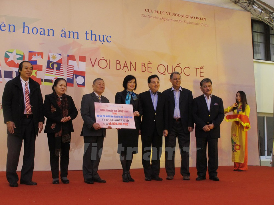 Nguyen Nguyet Nga, esposa del vicepremier y canciller vietnamita, Pham Binh Minh, y la embajadora malasia, Lim Kim Eng, concedieron obsequios a personas pobres. (Fuente: VNA)