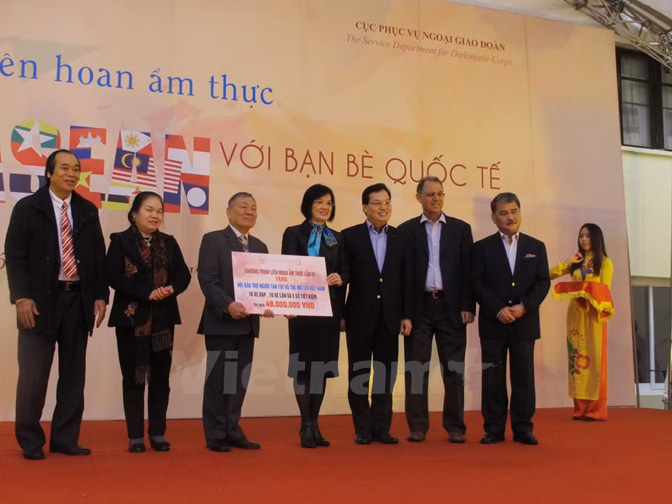 Nguyen Nguyet Nga, esposa del vicepremier y canciller vietnamita, Pham Binh Minh, y la embajadora malasia, Lim Kim Eng, concedieron obsequios a personas pobres. (Fuente: VNA)