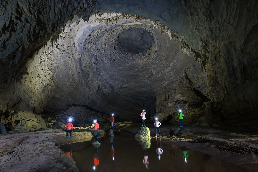 Como parte de su recorrido, Hoang My y su grupo visitaron también la cueva Tien (cueva de hadas). Durante la temporada de inundaciones en la provincia Quang Binh, la mayoría de las cuevas se inundan, pero Hang Tien se ubica en la parte superior, por lo que todavía es posible visitarla. Incluso la temporada de lluvias aquí también crea increíbles obras maestras que ninguna otra temporada tiene, como las cascadas dentro de la cueva. Es una cueva seca, que solo crea arroyos en la temporada lluviosa. El nombre de la cueva Tien se origina en la leyenda de que este es el lugar donde las hadas descendieron desde el cielo para contemplar el paisaje. La población local considera que la cueva Tien es un lugar sagrado (Fuente: Vietnamplus)