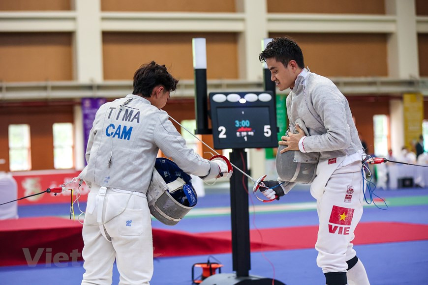De manera brillante, Vu Thanh An de Vietnam obtuvo una abrumadora victoria frente a su rival de Camboya. Por tanto, la estrella de la selección vietnamita de esgrima se alzó con una medalla de oro en el evento de sable masculino individual de los Juegos Deportivos del Sudeste Asiático (SEA Games 31). El esgrimista de Vietnam derrotó a su rival tailandés, Srinualnad Voragun, en el partido final con el resultado 15-17, y defendió con éxito su medalla de oro en los SEA Games. La selección vietnamita de esgrima continuará compitiendo mañana en las pruebas masculina y femenina. Al participar en los SEA Games 31, los deportistas vietnamitas apuntan a ganar 140 medallas de oro y liderar la clasificación por países en el evento, en curso en este país indochino. (Foto: Vietnam+)