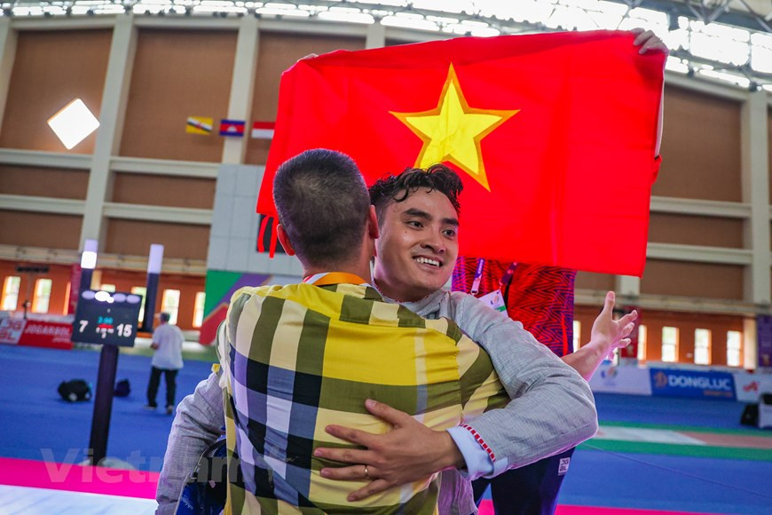 Inmerso en una gran emoción, el entrenador Pham Anh Tuan abraza a Vu Thanh An después de ganar la primera medalla de oro para la selección de esgrima de Vietnam en los SEA Games 31. Al intercambiar con la Agencia Vietnamita de Noticias, el entrenador en jefe Pham Anh Tuan dijo que con la capacidad actual del equipo nacional de esgrima, el país puede establecer una meta más alta de ganar cinco oros en este deporte de los SEA Games 31. Al participar en SEA Games 31, los deportistas vietnamitas apuntan a ganar 140 medallas de oro, 77 de plata y 71 de bronce en la cita deportiva regional, que se organiza cada dos años con la participación de miles atletas procedentes de 11 países del Sudeste Asiático (Foto: Vietnam+)