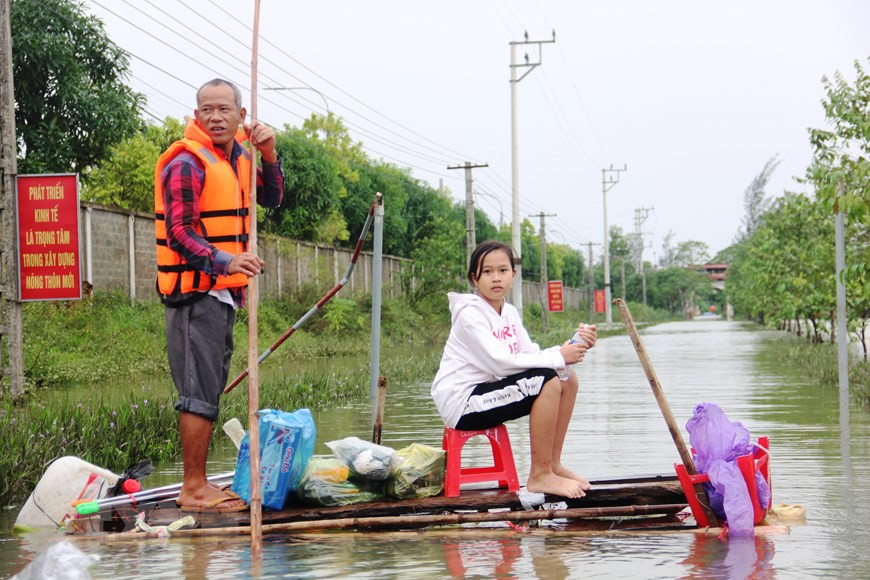 Un padre y su hija en la comuna de Tan Lam Huong, en Ha Tinh, utilizan una balsa hecha de tallos de árbol platanero para recoger las vituallas (Fuente: VNA)
