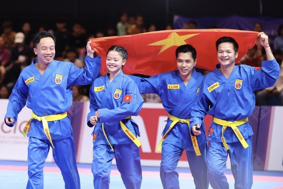 Los atletas Lam Thi Thuy My, Le Toan Trung, Doan Hoang Tham y Lam Tri Linh celebraron su victoria después de ganar una medalla de oro en la disciplina de Vovinam en los SEA Games 32 (Fuente: VNA)