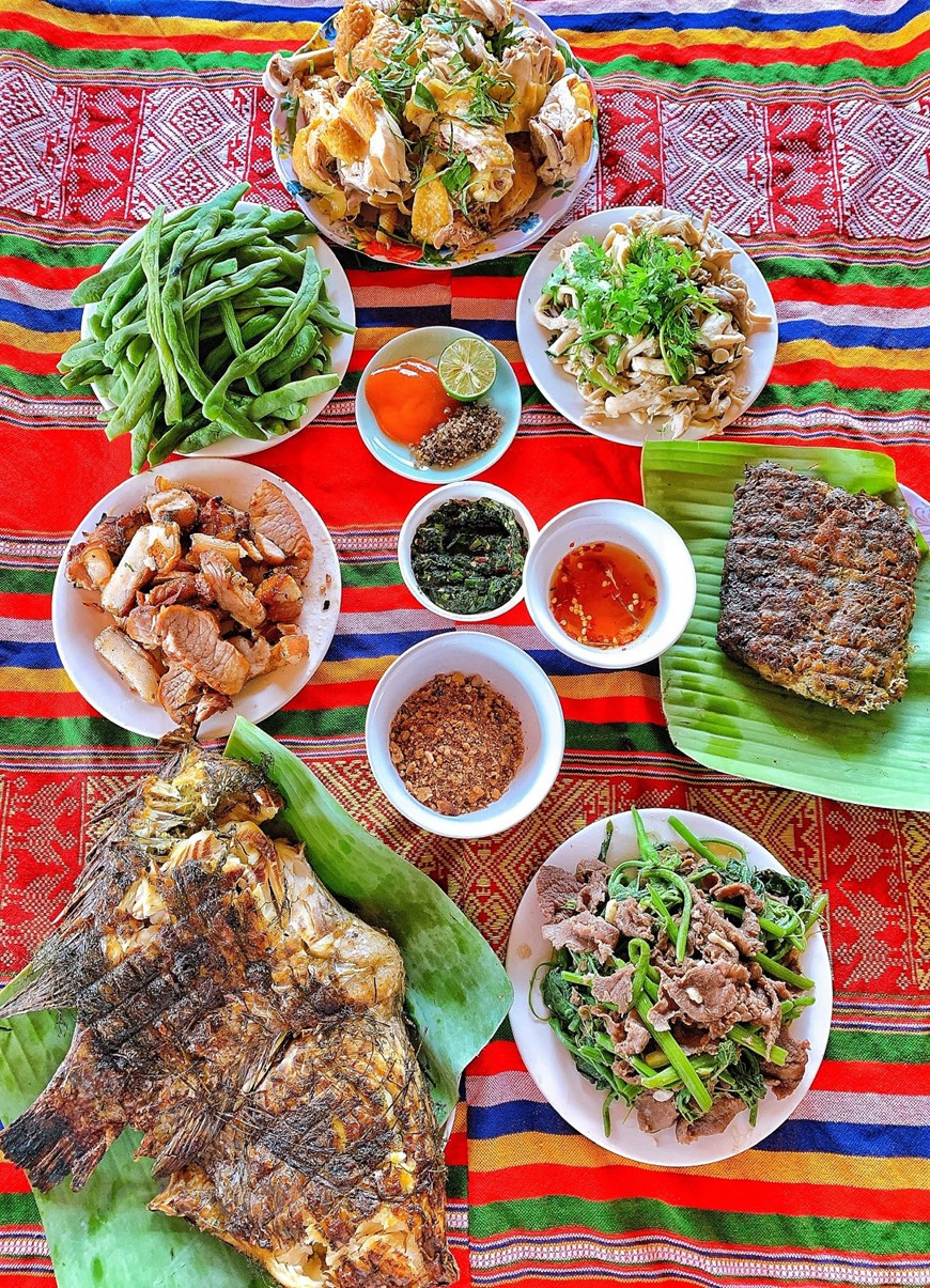 En la foto se aprecia un almuerzo típico del pueblo Thai con especialidades tradicionales. El principal alimento de la gente proviene de su propia localidad, como cerdos, pollos, vacas, entre otros. Los platos a la parrilla con métodos de cocción al asado tienen un sabor especial que también cautiva a muchos visitantes nacionales y extranjeros. Además, las salsas hechas a mano también elevan significativamente el sabor de los platos del pueblo de Doi. Los ingredientes para las diferentes salsas incluyen la de pescado, chilli, limón, pimienta, vinagre, maní, hojas de hierbas típicas, entre otros ingredientes, que nunca faltan en la comida de los pobladores Thai. (Foto: Mai Mai/Vietnam+)