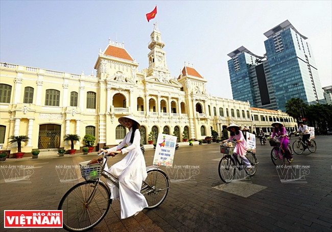 Las muchachas en Ao dai participan en un desfile de bicicletas en la calle de Nguyen Hue (Fuente: VNA)