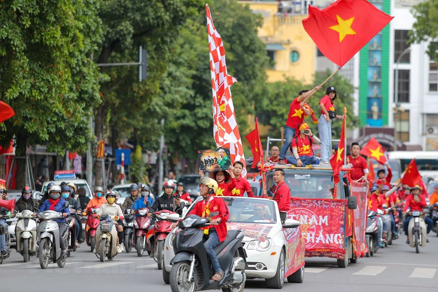Los fanáticos se visten de camiseta roja y llevan pancartas (Foto: Minh Son/Vietnamplus)