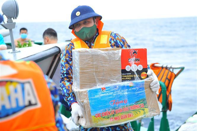 Las cajas de regalos y artículos de primera necesidad se trasladan desde el barco Khanh Hoa – 01 (561) a las canoas para distribuirlos a los oficiales y soldados en las islas del distrito de Truong Sa (Fuente: VNA)