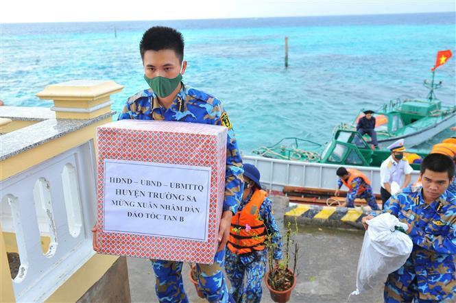 Los barcos transportan regalos y artículos de primera necesidad a los oficiales, soldados y pobladores del distrito isleño de Truong Sa. En la foto: Solados de la isla de Toc Tan B reciben regalos por el Tet (Fuente: VNA)
