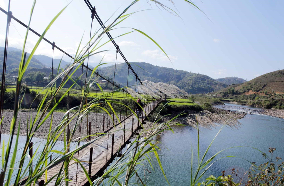 Los aldeanos de Na Khuong construyen un puente de bambú sobre el río Nam Mu para llevar a los turistas al otro lado. (Fuente: VNA)