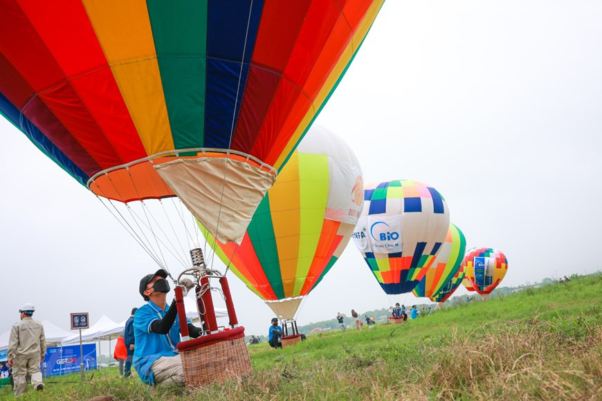 Tres globos aerostáticos que cumplen con los estándares internacionales serán utilizados en el evento "Get on Hanoi 2022" y el lanzamiento de nuevos productos turísticos de Hanoi. El cuerpo del globo tiene una altura de entre 22 y 25 metros, el diámetro más grande es de unos 17-18 metros. La capacidad de vuelo del globo es de más de 500 kilógramos, por lo que puede transportar tres adultos o 4-5 niños, sin incluir al piloto. En el evento también cuenta con otros veinte globos aerostáticos, uno de clase 1 (AX-1) con una altura de 10-12 metros que se utiliza habitualmente para los festivales. (Foto: Vietnam+)