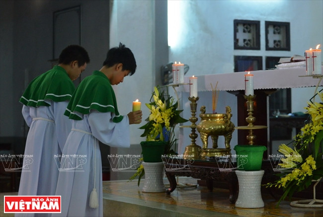 Los acólitos ofrecen velas en el altar antes de un servicio. Foto: Thanh Hoa