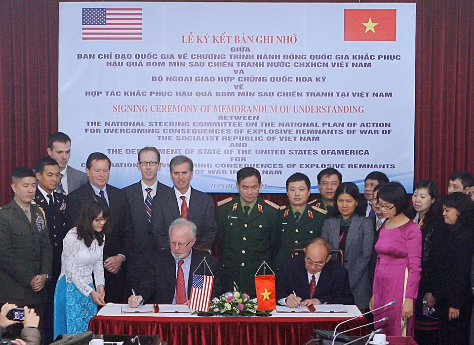 Firma de un Memorando de Entendimiento sobre la cooperación para superar las consecuencias de las bombas y minas remanentes de la guerra, entre el Comité Directivo Nacional de Vietnam del Programa de Acción Nacional y el Departamento de Estado de los Estados Unidos, 16 de diciembre de 2013. Foto: VNA