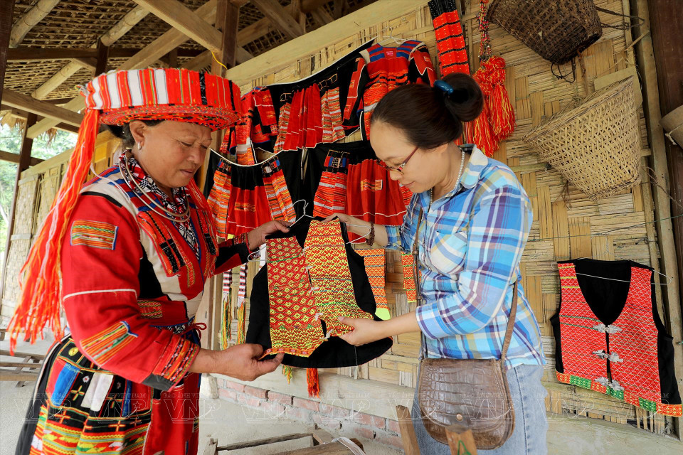 Un visitante conoce la vestimenta de la etnia Pa Then. (Foto: VNA)