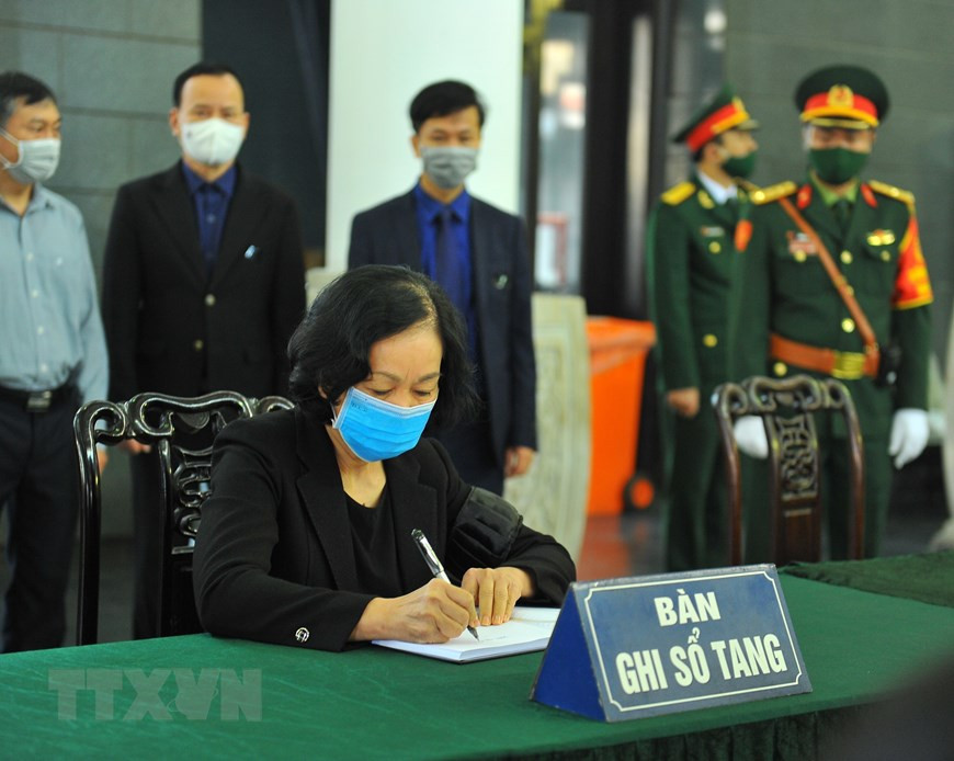 La miembro del Buró Político y jefa de la Comisión de Movilización de Masas del Comité Central del Partido Comunista, Truong Thi Mai, escribe en el libro de condolencias. (Foto: VNA)