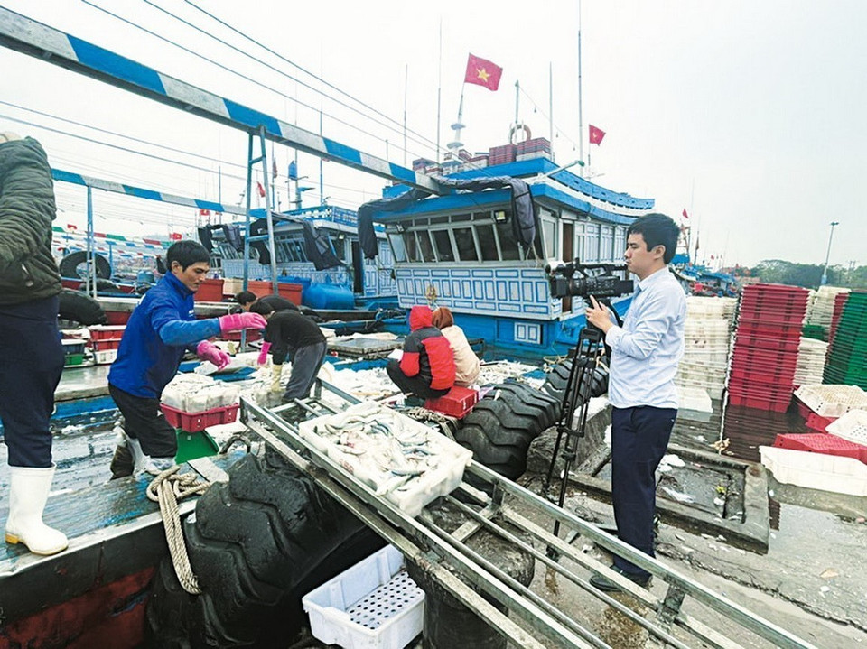 El reportero Nguyen Dinh Nam, de la Oficina de Agencia Vietnamita de Noticias de Vietnam en Thanh Hoa, en el puerto pesquero de Lach Bang, Nghi Son, enero de 2023. (Foto: VNA)
