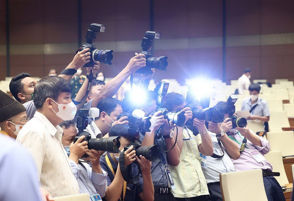 Grupo de fotoperiodistas trabajan en el primer período de sesiones de la Asamblea Nacional de XV Legislatura, julio de 2021. (Foto: VNA)