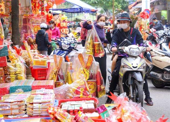 Los pobladores compran papel votivo para preparar la ofrenda dedicada a Ong Cong, Ong Tao (Fuente: VNA) 