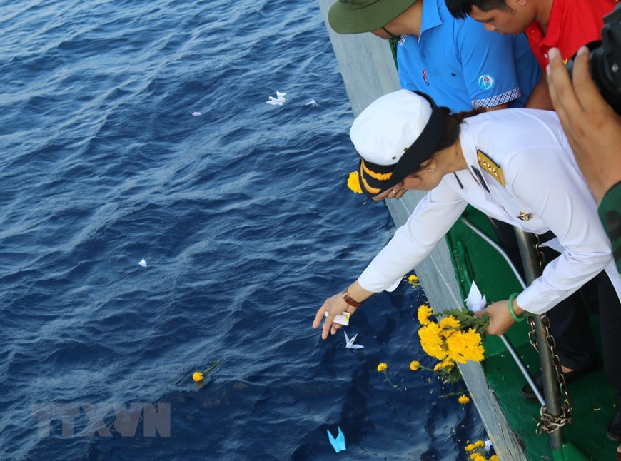 La teniente coronel Tran Thi Thuy, hija del difunto héroe de las fuerzas armadas Tran Van Phuong, colocó inciensos para rendir homenaje a los mártires. (Fuente: VNA)