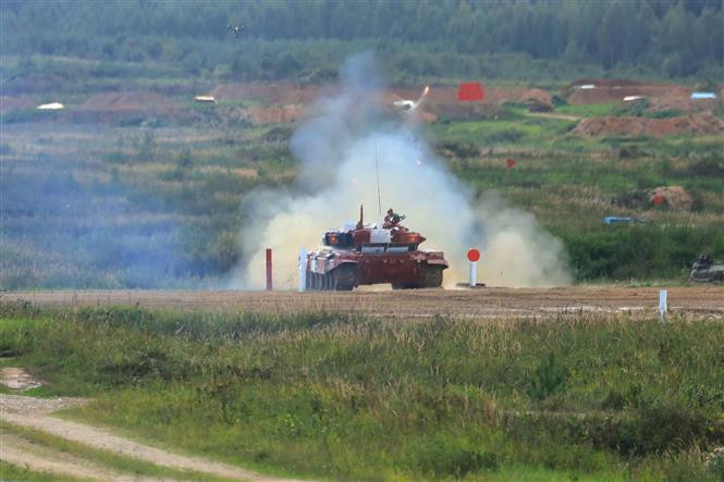 El comandante Vu Ba Trong y el artillero Le Quang Hiep con la bandera nacional desfilan por el escenario después de completar la prueba. (Fuente: VNA)