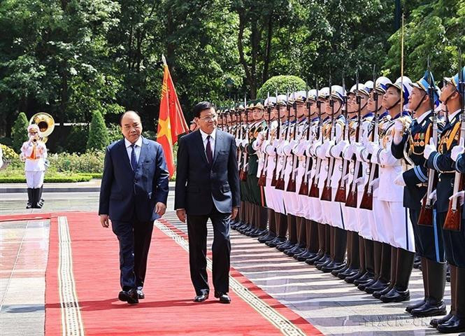 El presidente Nguyen Xuan Phuc encabeza la ceremonia de recepción al secretario general del Partido Popular Revolucionario de Laos y presidente de este país, Thongloun Sisoulith, durante su visita a Vietnam (28 de junio de 2021) (Fuente: VNA)