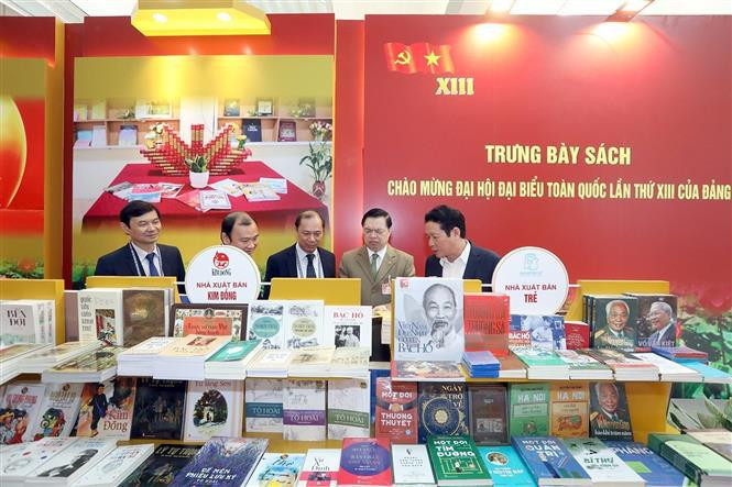 Las delegadas disfrutan de las publicaciones en la exposición. (Foto: VNA) 