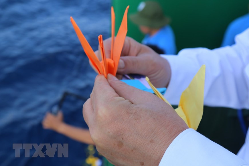 Las grullas de papel fueron arrojadas al mar por oficiales y soldados en el barco Truong Sa 571, en conmemoración de los mártires que se sacrificaron heroicamente para proteger las islas sagradas de la Patria. (Fuente: VNA)