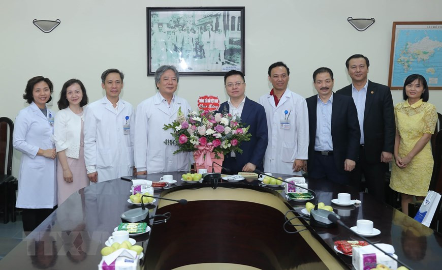El miembro del Comité Central del Partido Comunista de Vietnam y director general adjunto de la VNA, Le Quoc Minh, felicita al directivo del Hospital de Amistad Viet-Duc. (Fuente: VNA)