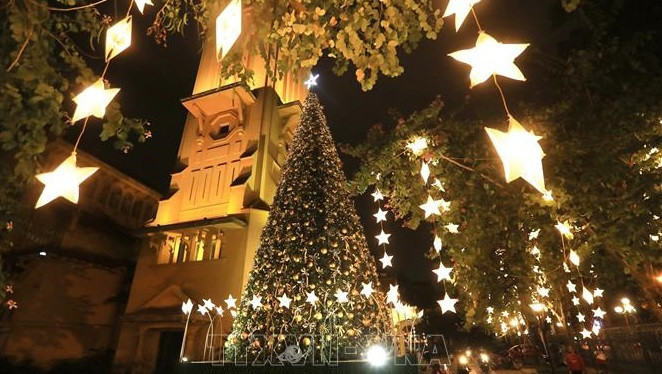 El gran pino está decorado con hileras de luces brillantes que destacan la iglesia parroquial de Cua Bac. Foto: VNA