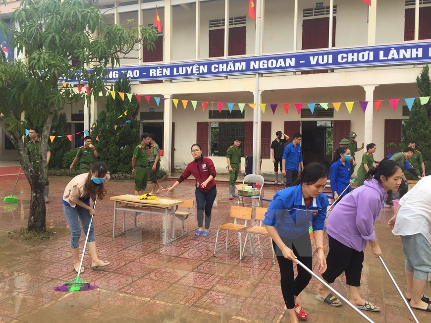 Los militares y el personal de la escuela primaria de Vo Liet, en el distrito de Thang Cuong, limpian el sitio tan pronto como el nivel de agua baja (Foto: VNA)