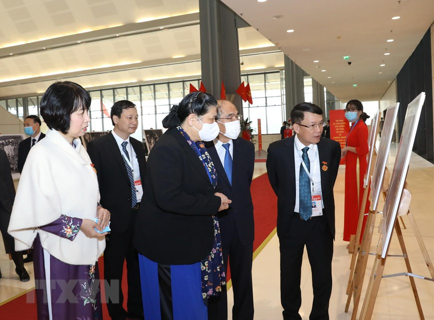 Dirigentes de la Agencia Vietnamita de Noticias (VNA) presentan a la vicepresidenta de la Asamblea Nacional, Tong Thi Phong, y al extitular del Parlamento Nguyen Sinh Hung las fotos de la VNA exhibidas en el evento. (Fuente: VNA)