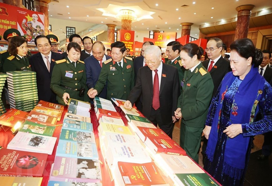 El secretario general del Partido Comunista, presidente del país y el también secretario de la Comisión Militar Central, Nguyen Phu Trong, y delegados visitan una exhibición de artículos militares (Fuente:VNA) 
