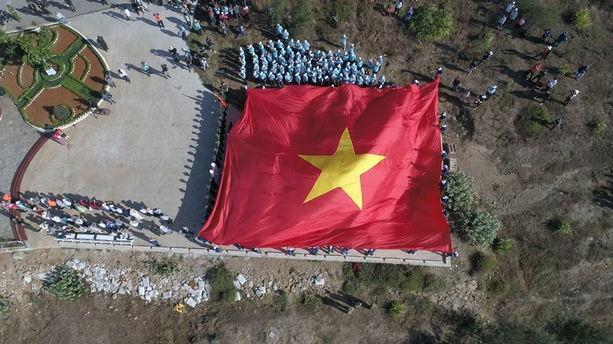Después de la ceremonia, la bandera nacional de 250 metros cuadrados se extendió ampliamente en la ladera de la montaña de Thoi Loi. La cima también se considera uno de los sitios de interés turístico más populares de este distrito isleño, ya que es una de las montañas más altas en el país. En este lugar, se pueden encontrar señales de las erupciones volcánicas ocurridas a lo largo de la historia, como paredes de rocas elevadas, una pagoda construida en una de sus cuevas de lapillis estratificadas y un lago de agua dulce, en lo que fue un cráter del volcán en el pasado. (Foto: Vietnam +)