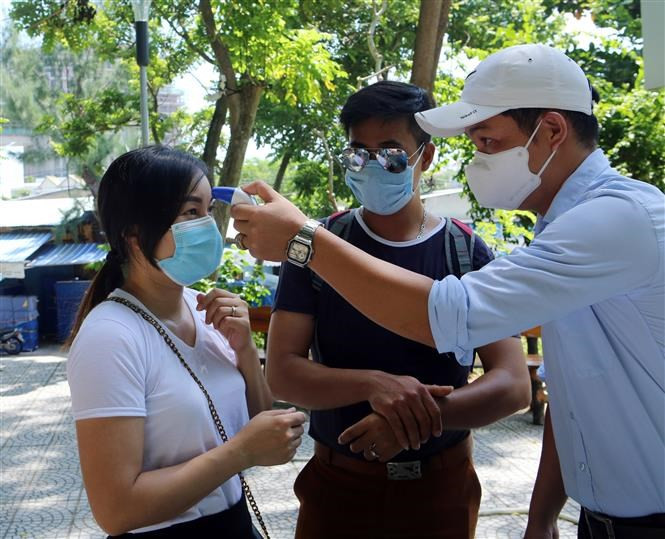 Se mide la temperatura corporal de los visitantes antes de su entrada al complejo turístico de Ngu Hanh Son (Foto: VNA)