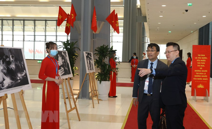 El subdirector general de la VNA, Le Quoc Minh, presenta a un delegado las fotos de la VNA. (Fuente: VNA)