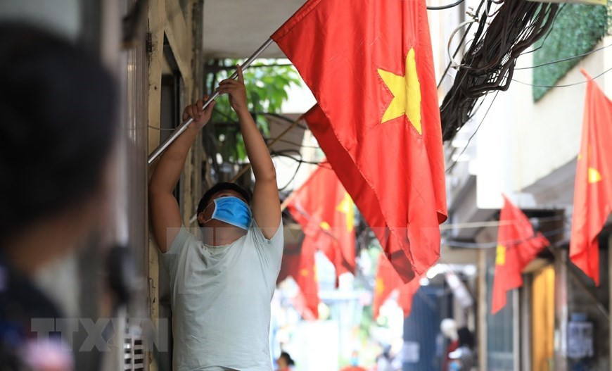 En un callejón del centro de Hanoi, todos los hogares cuelgan banderas para celebrar el Día Nacional (Foto: VNA)