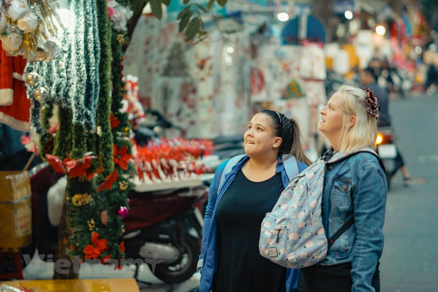 Los turistas extranjeros también aprovechan la ocasión para disfrutar del ambiente navideño de esta calle. La Navidad (en latín: nativitas, ‘nacimiento’) es una de las festividades más importantes del cristianismo, junto con la Pascua de resurrección y Pentecostés. Esta liturgia, que conmemora el nacimiento de Jesucristo en Belén, se celebra el 25 de diciembre en la Iglesia católica, en la Iglesia anglicana, en algunas comunidades protestantes y en la mayoría de las Iglesias ortodoxas. El 25 de diciembre es un día festivo en muchos países celebrado por millones de personas en todo el mundo y también por un gran número de no cristianos. (Foto: Vietnam+)
