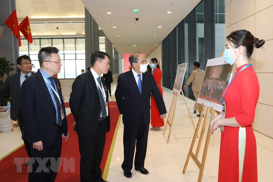 Dirigentes de la Agencia Vietnamita de Noticias (VNA) presentan al expresidente del Parlamento Nguyen Sinh Hung las fotos de la VNA. (Fuente: VNA)