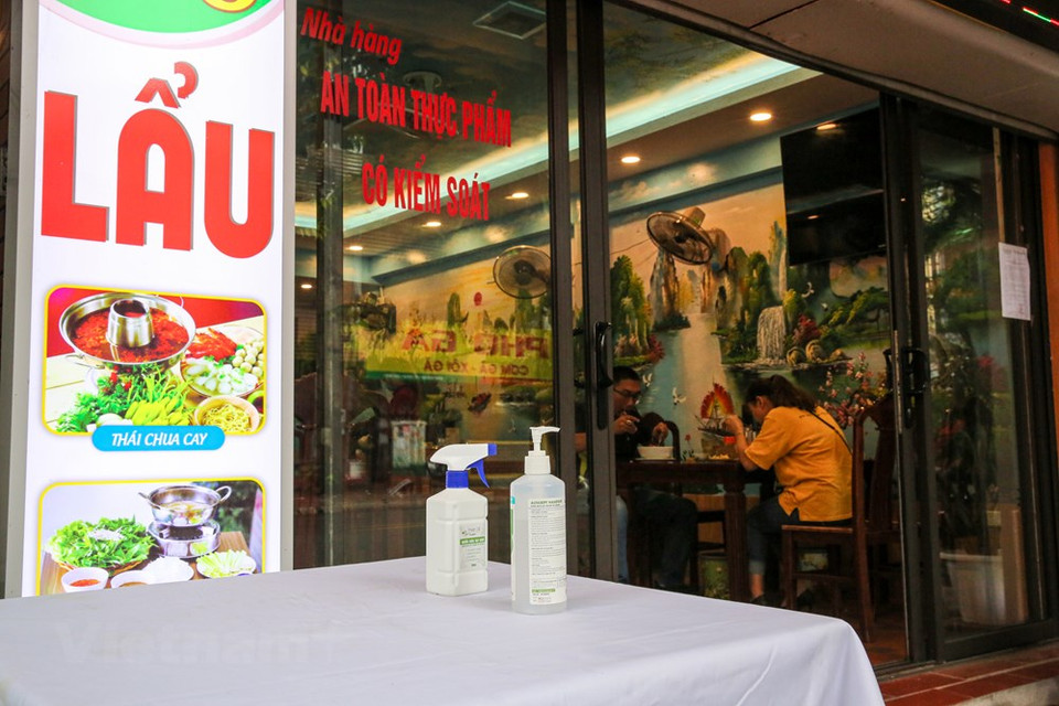 Por la mañana del 19 de agosto en Hanoi, todos los restaurantes y cafeterías siguen estrictamente la dirección de las autoridades municipales sobre la prevención y la lucha contra la pandemia de COVID-19. Se trata de una epidemia ocasionada por el virus coronavirus 2 del síndrome respiratorio agudo grave (SARS-CoV-2). Se identificó por primera vez en diciembre de 2019 en la ciudad de Wuhan, capital de la provincia de Hubei, en China, al reportarse casos de un grupo de personas enfermas con un tipo de neumonía desconocida. Los afectados tenían vinculación con ló trabajadores del Mercado Mayorista de Mariscos del Sur de China de Wuhan. La Organización Mundial de la Salud (OMS) la reconoció como una pandemia global el 11 de marzo de 2020. (Foto: Minh Son/Vietnam +)