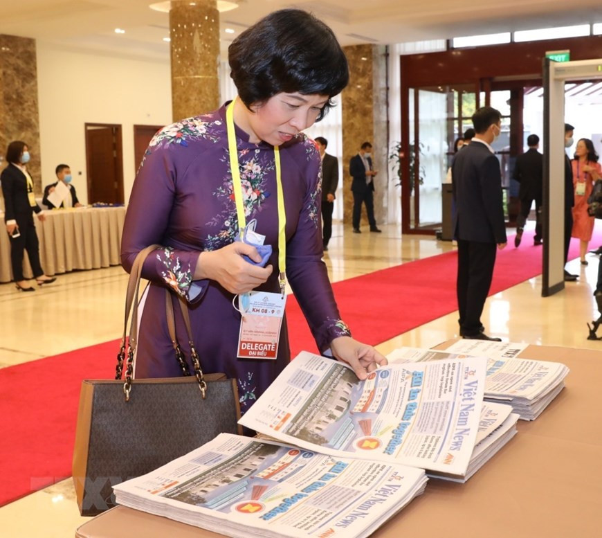 Una delegada sigue el periódico de Việt Nam News en la ceremonia inaugural de AIPA-41, (Fuente: Van Diep / VNA)