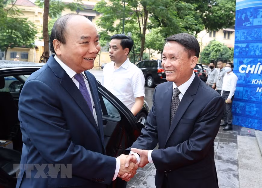 El director general de la Agencia Vietnamita de Noticias (VNA), Nguyen Duc Loi, da la bienvenida al primer ministro Nguyen Xuan Phuc a su llegada al acto conmemorativo del aniversario 75 de la fundación de esta agencia (Foto: VNA)